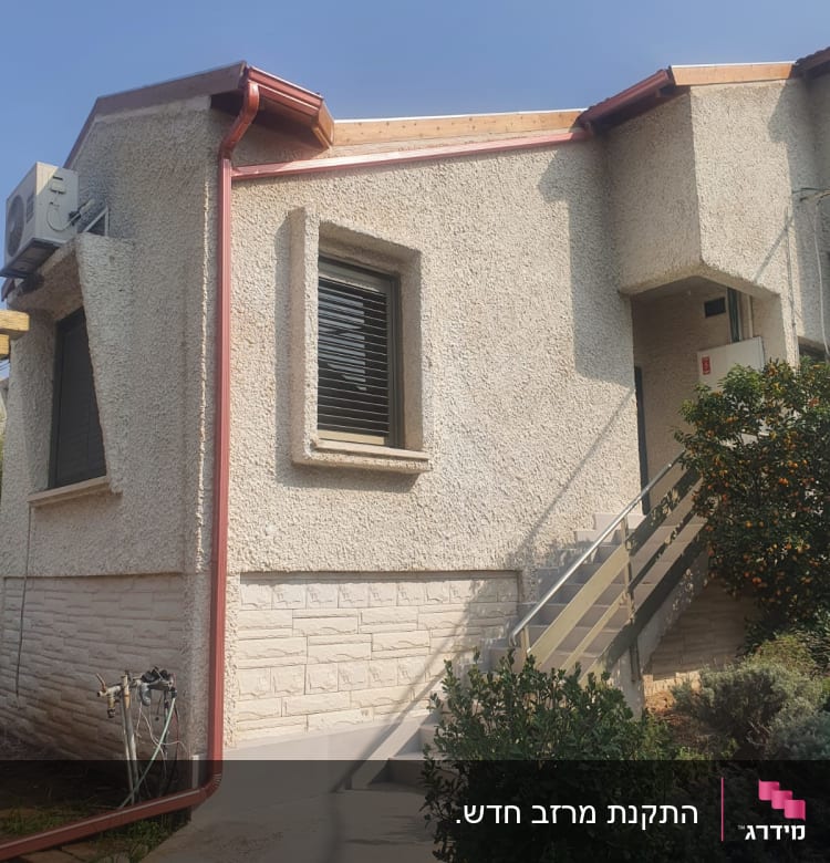 גג עם מרזב מתכת אדום על בית